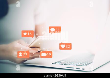 Hände von Frau, die Smartphone mit Blick auf Social Media im Internet online, Symbol mit Emotionen mit vielfältigen, Interaktion Benachrichtigung und Kommunikation Stockfoto