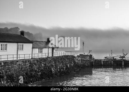Schwarz-Weiß-Bild bei Sonnenaufgang aufgenommen, am Cobb Harbour, bei Lyme Regis in Dorset. Szene der französischen Leutnant-Frau. Speicherplatz kopieren Stockfoto