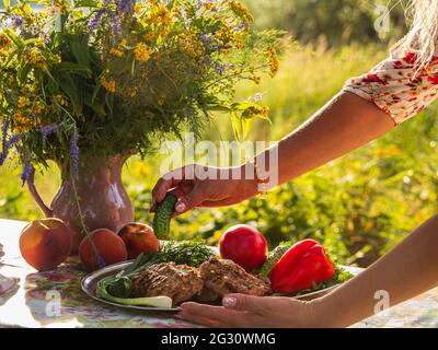 Stillleben im Freien mit Grill und Blumenstrauß Stockfoto