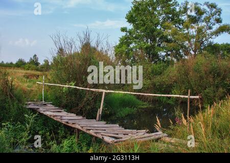 Alte Holzbrücke über den Bach im verlassenen Dorf Stockfoto