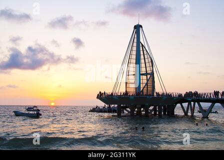 Die Segelskulptur und der Pier wechseln nachts die Farben – der Pier wurde 2013 eingeweiht und wurde vom mexikanischen Architekten Jesus Torres Vega entworfen Stockfoto