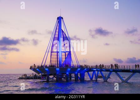 Die Segelskulptur und der Pier wechseln nachts die Farben – der Pier wurde 2013 eingeweiht und wurde vom mexikanischen Architekten Jesus Torres Vega entworfen Stockfoto