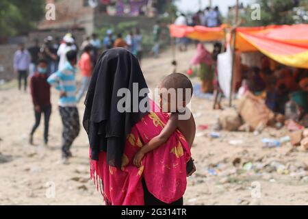 Neu-Delhi, Indien. Juni 2021. Eine Frau, die mit einem Kind außerhalb des Lagerbereichs gesehen wurde, während der Zeit danach. Im Rohingya-Flüchtlingslager brach ein Feuerereignis aus, bei dem über 50 Rohingya-Flüchtlinge in den Shanties enttüncht wurden. Die Brandursache ist noch nicht ermittelt. Kredit: SOPA Images Limited/Alamy Live Nachrichten Stockfoto