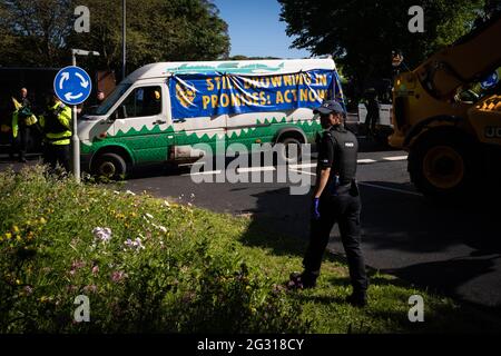 St Ives, Großbritannien. Juni 2021. Ein Polizeibeamter kommt an einem Bus der „Extinction Rebellion“ vorbei, der einen Kreisverkehr in der Nähe des Geländes für den G7-Gipfel blockierte und so den Verkehr umleiten lässt. Extinction Rebellion ergreift Maßnahmen am dritten und letzten Tag des G7-Gipfels. Kredit: Andy Barton/Alamy Live Nachrichten Stockfoto