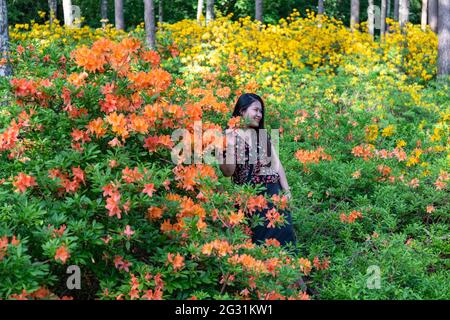 Frau, die im Haaga Rhododendron Park in Helsinki, Finnland, für die Kamera posiert Stockfoto