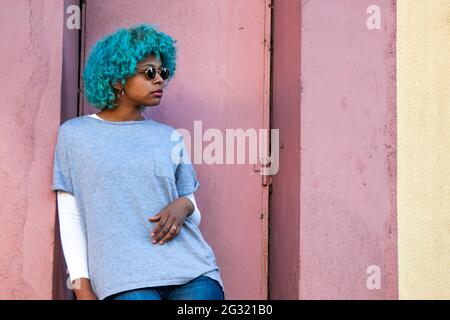 afroamerikanisches Mädchen mit Sonnenbrille und farbigen Haaren auf der Straße Stockfoto