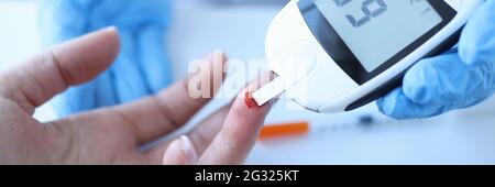 Arzt, der den Blutzucker des Patienten mit Glukosimeter in Nahaufnahme misst Stockfoto