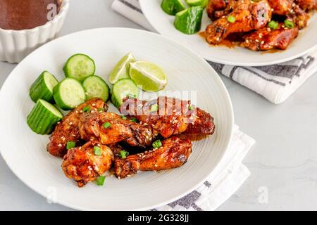 Süß-würzig gebackene Thai Chicken Wing mit Gurke und Zitrone Stockfoto