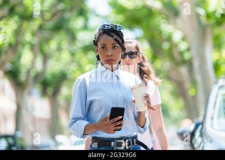 Schöne afroamerikanische junge Frau, die auf der Straße läuft: Selektiver Fokus. Lifestyle-Konzept. Stockfoto