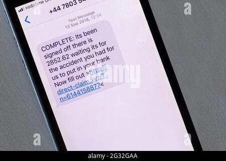Eine auf einem iphone angezeigte Betrugsmeldung, die vorgibt, über die Zahlung eines Versicherungsanspruchs zu berichten. Stockfoto