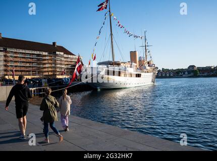 13. Juni 2021, Dänemark, Sønderborg: Passanten gehen an der königlichen Yacht Dannebrog vorbei, die vor Sønderborg (Sonderburg) vertäut ist und auf der ein Abendessen der dänischen Königin stattfindet. Foto: Bernd von Jutrczenka/dpa Stockfoto