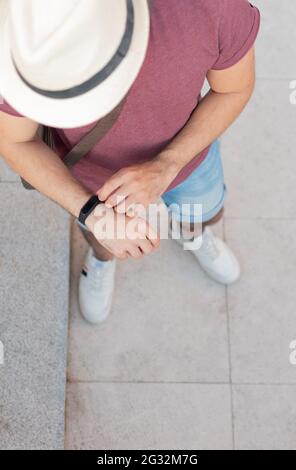 Draufsicht auf eine nicht erkennbare Person, die auf seine Smartwatch schaut. Stockfoto