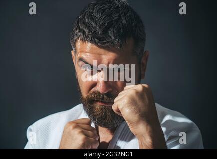 Karate Mann im Kimono in Kampfhaltung. Bärtiger Rüde macht Karate-Training Stockfoto