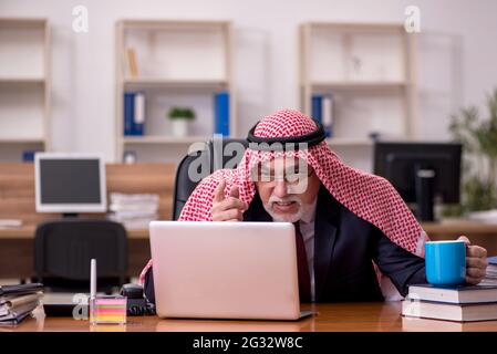 Gealterter arabischer Angestellter, der während der Pause Kaffee trinkt Stockfoto