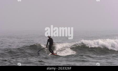 Am 26. März 2021 surft ein Mann in der Nähe der Johnson Beach National Seashore in Florida. Stockfoto