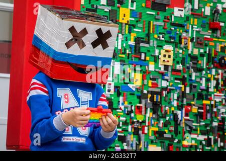 Moskau, Russland. 12. Juni 2021 EIN Junge mit einer Kiste in den Farben der russischen Trikolore auf dem Kopf in der Nähe des Eingangs zum RoboStation-Unterhaltungszentrum im VDNH-Ausstellungskomplex in Moskau während der Feier des Russland-Tages Stockfoto