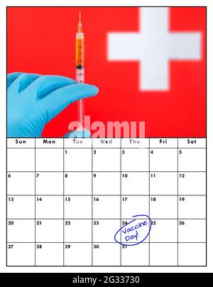 Ein Kalender mit dem Impftag, der in blauem Stift geschrieben und eingekreist ist. Oben ist ein Bild einer Hand, die einen blauen Handschuh aufziehen und sich auf eine Impfung vorbereiten. Stockfoto