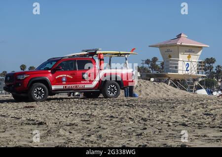 Roter Rettungsschwimmer-LKW auf Strandpatrouille an einem Rettungsschwimmer-Turm Huntington Beach California Stockfoto