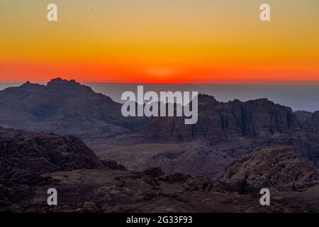 Orangerot malerischer Sonnenuntergang über den Bergen und dem Tal im Wadi Araba, Jordanien Stockfoto