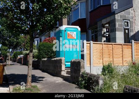 Tragbare Toilettenkabine im Garten des Hauses während der Bauarbeiten Stockfoto