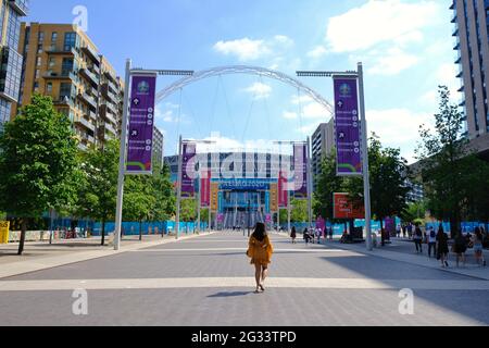 London, Großbritannien. Eine Frau geht an einem sonnigen Tag auf dem Olympischen Weg zum Wembley-Stadion im Hintergrund. Stockfoto