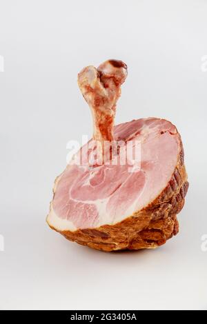 Geräucherter Schweineschinken mit großem Knochen auf weißem, isoliertem Hintergrund. Nahaufnahme. Stockfoto