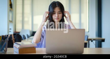 Ein Mädchen übt vor dem Online-Kurs per Video die Grundkursübungen auf dem Laptop. Soziale Distanzierung.Bleib zu Hause. Neuer Normalwert. Covid-19 Coronavirus-Konzept. Stockfoto