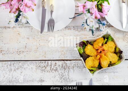 Frittierte panierte Garnelen mit Salat und Tischset. Stockfoto