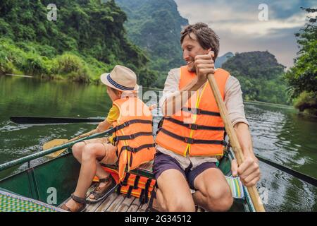 Glückliche Familien-Touristen in Trang an Scenic Landscape Complex in Ninh Binh Provinz, Vietnam EIN UNESCO-Weltkulturerbe. Wiederaufnahme des Tourismus in Stockfoto