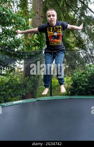 Lynwood, Washington, USA. 18-jähriger Junge springt auf seinem Trampolin. (MR) Stockfoto