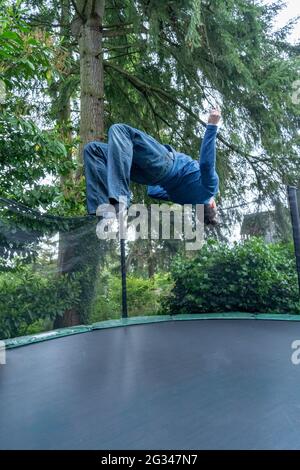 Lynwood, Washington, USA. 39-jähriger Mann springt auf seinem Trampolin. (MR) Stockfoto