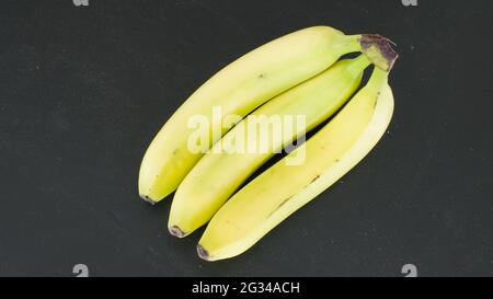 Drei Bananen auf schwarzem Hintergrund Stockfoto