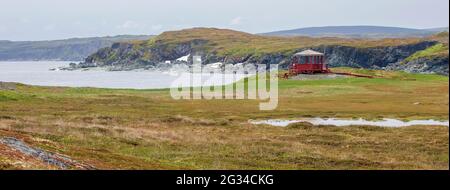 Ein leuchtend roter Pavillon an der Küste von Neufundland in Goose Cove. Stockfoto