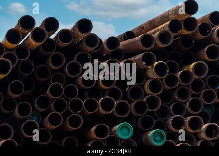 Stapel von alten rostigen runden Metall-Industrierohr. Stahlrohrstapel im Werkslager Industriematerial. Metallkorrosion. Stapel rostiger Rohre. Stockfoto