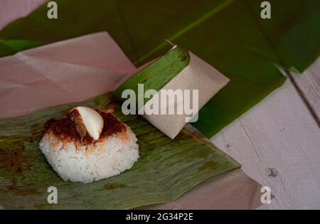 Eine Portion Nasi Lemak, Reis gekocht mit Kokosmilch, ein beliebtes lokales Gericht in Malaysia. Selektive Fokuspunkte. Unscharfer Hintergrund Stockfoto