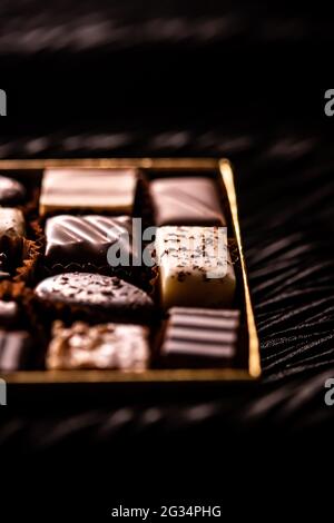 Schweizer Pralinen in Geschenkbox, verschiedene Luxus-Pralinen aus dunkler und milcher Bio-Schokolade in der Schweizer Chocolaterie, süße Dessertspeisen wie Stockfoto