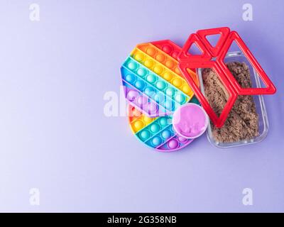 Set von bunten Fidget Spielzeug zu helfen, Stress und Angst bei Kindern und Erwachsenen auf lila zu reduzieren Stockfoto