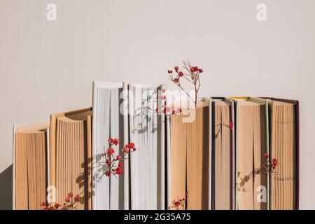 Stapel von alten Büchern mit Babys Atem Blumen. Gemütliches Lesen. Zarte rosa Gipsophila-Blüten. Slow-Living-Konzept. Einheit mit der Natur. Selektiver Fokus. Stockfoto