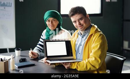 Down-Syndrom-Mann, der die Bildungsklasse im Gemeindezentrum besucht, einschließlich der Behinderten. Stockfoto