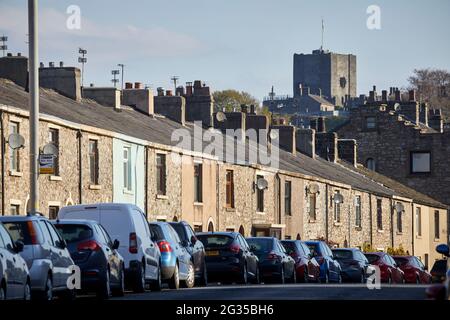 Clitheroe Castle parkte Autos vor steinernen Reihenhäusern entlang der Whalley Road, Ribble Valley in Lancashire Stockfoto