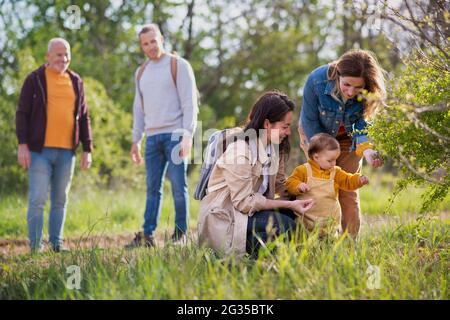 Kleines Kleinkind mit Eltern und Großeltern auf einem Spaziergang im Freien in der Natur. Stockfoto