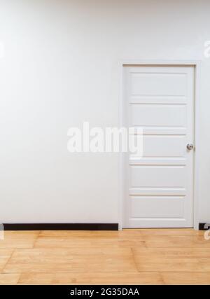 Leere Innenausstattung mit weißer Wand, weißer Tür und Holzboden. Hintergrund innen Stockfoto