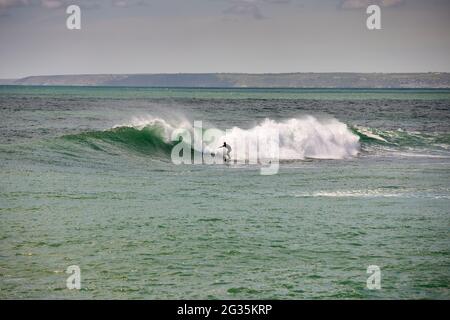 Das kornische Touristenziel Porthleven, Cornwall, England, stellte Surfer an der Küste vor, die Wellen reiten Stockfoto