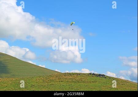 Die Menschen genießen das Paragliding über dem üppigen Gipfel des Kaukasus-Gebirges in Georgien Stockfoto