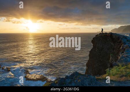 Silhouette eines Mannes, der während des Sonnenaufgangs auf den Klippen steht, Madeira Island, Portugal Stockfoto