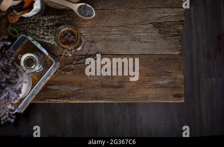 Hintergrund des Essens in der unteren Ansicht von oben. Dunkel und moody. Holztisch mit einem Bouquet von Lavendel, eine Tasse Kaffee. Aromatherapie. Ort für Ihren Text. A Stockfoto