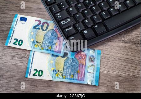 20 Euro Scheine und Computertastatur auf Holzhintergrund Stockfoto