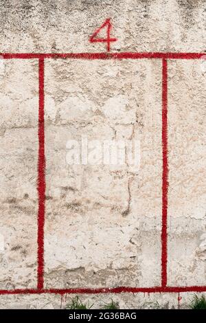 Rote Zahl 4 und roter Rahmen auf verwitterte Wand gesprüht Stockfoto
