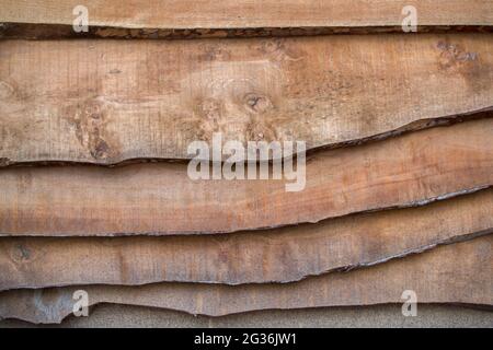 Eine Wand oder Zaun, konfrontiert und aus grob gehauen horizontal gelegten dünnen Brettern, mit einem gewölbten gekrümmten Rand, angedockt in mehreren Ebenen ein Brett auf einem Stockfoto