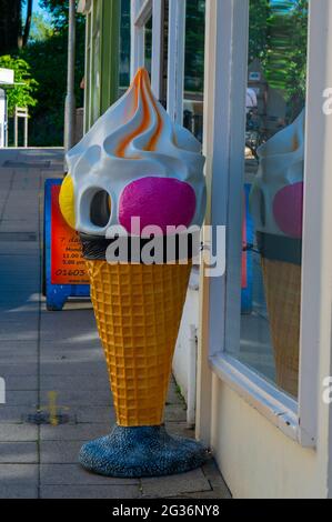 Ein großer, bunt gefärbter Eiskegel aus Kunststoff vor einer Eisdiele in Norwich Stockfoto